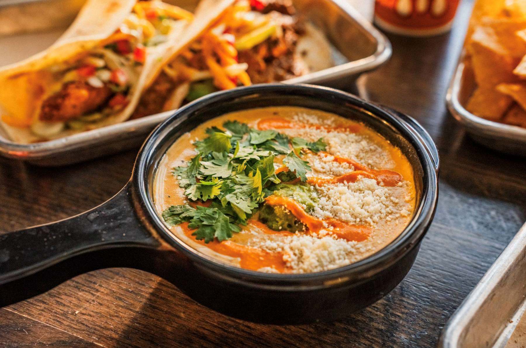 “Torchy’s Green Chile Queso and chips for National Queso Day”